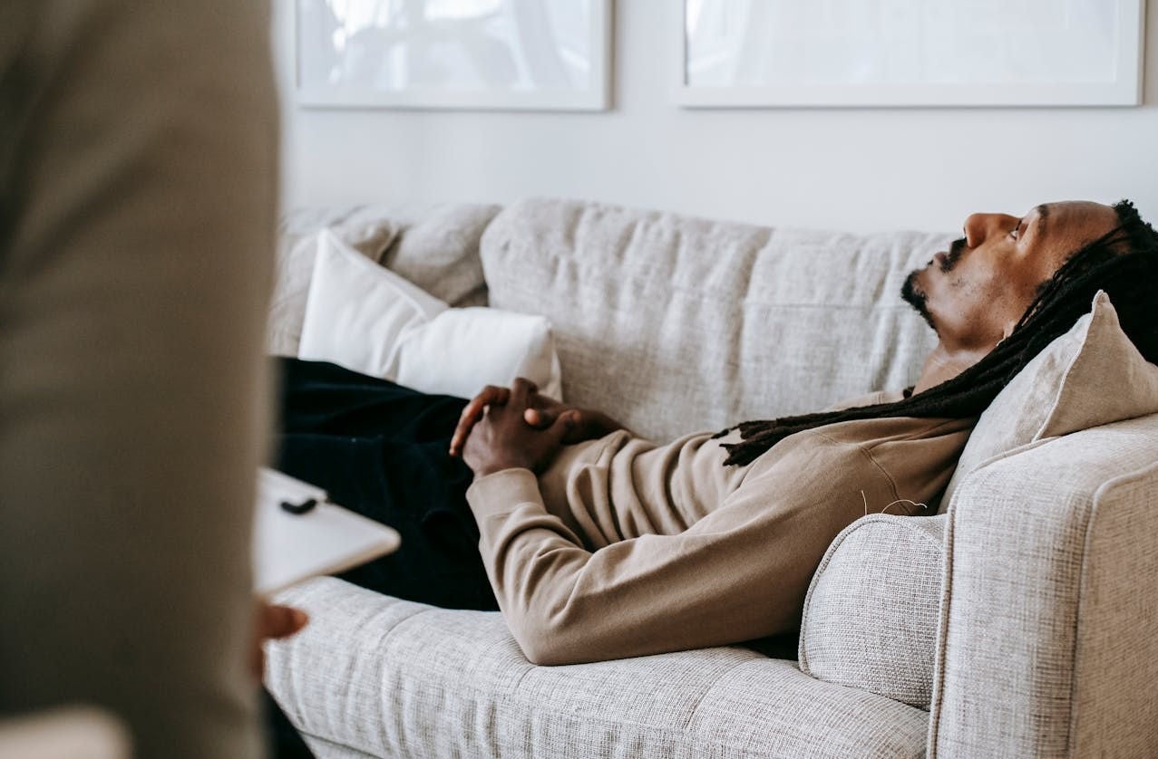 A man lying on a couch during a counseling session.