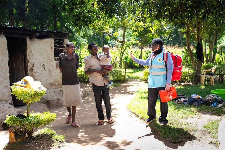 A community health worker talks to a family.