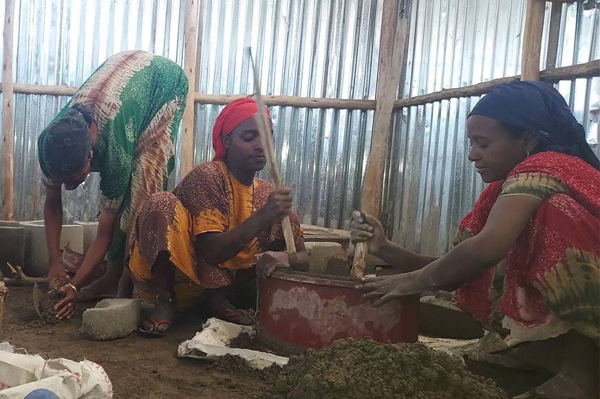 Women involved in an energy-efficient cookstove cooperative group participate in cookstove production.
