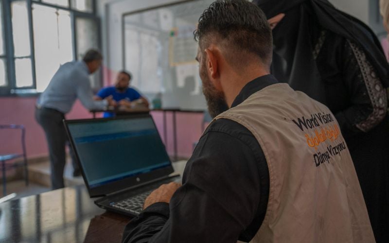 A World Vision worker working at a laptop