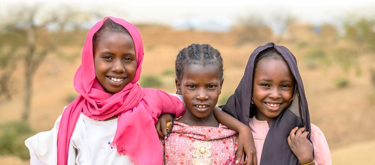 three girls stand together with hope