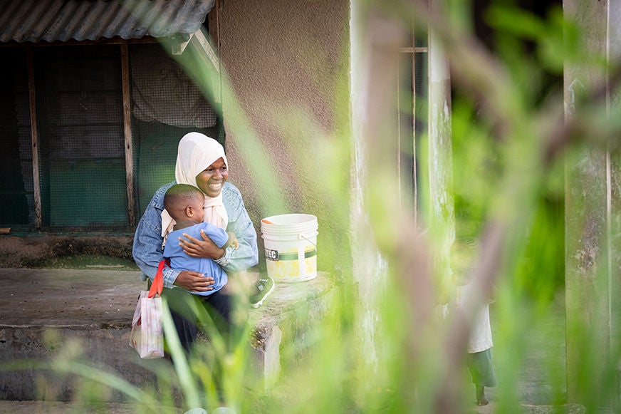 Amani and her son outside of their home