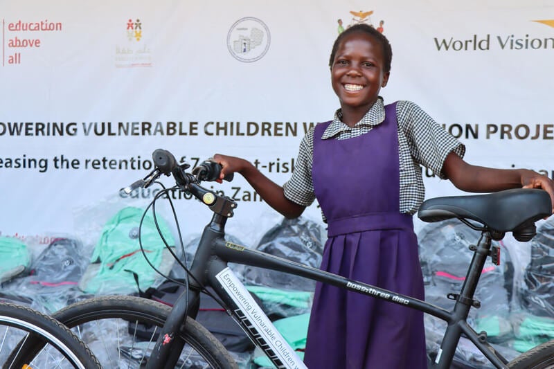 12-year-old Queen receiving and posing with her bicycle and bag.