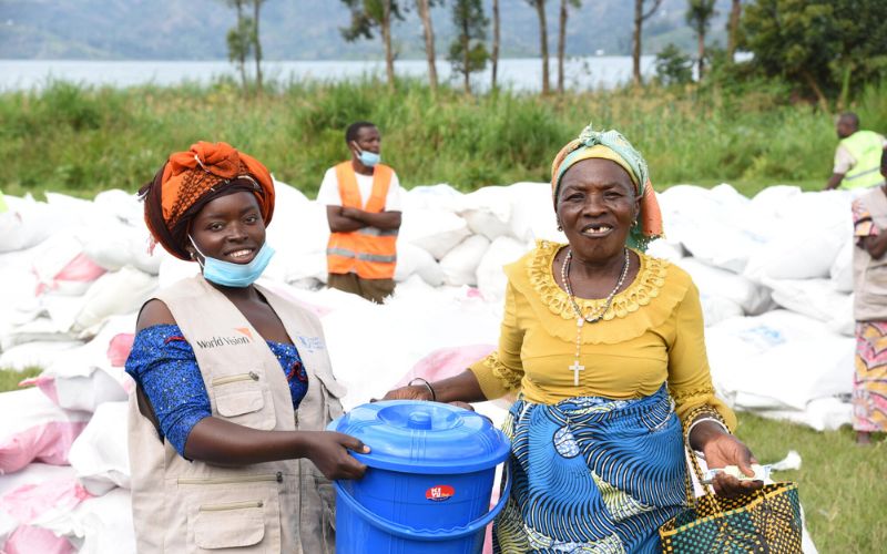 Two women smiling at the camera with aid around them