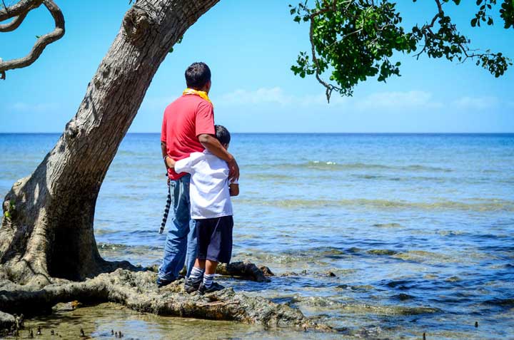 In the Philippines, a man and his son stand beside the ocean, in a country where clean water sources are often compromised by natural disasters.