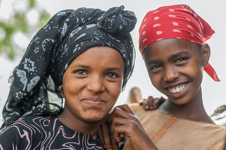 Friends smile and share a moment together in their community. (Photo: Jon Warren)