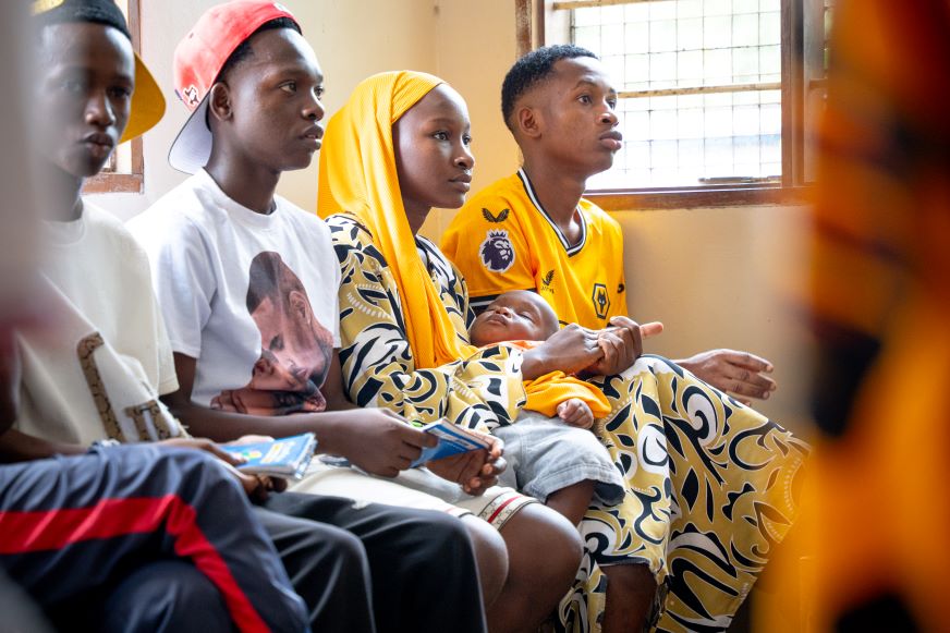 Three male adolescents and one female adolescent participate in an AHADI sexual and reproductive health and rights session.