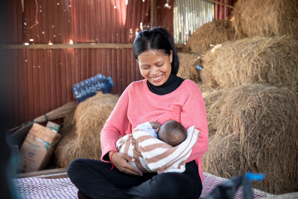 Som Chhin smiles down at baby Rany, who gained 2 kilograms that month.