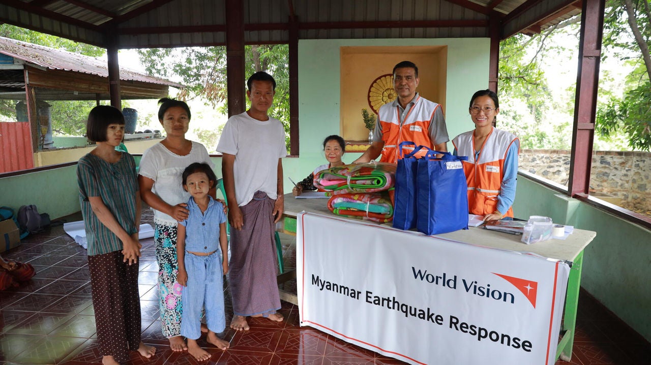 World Vision staff deliver kits to a family.