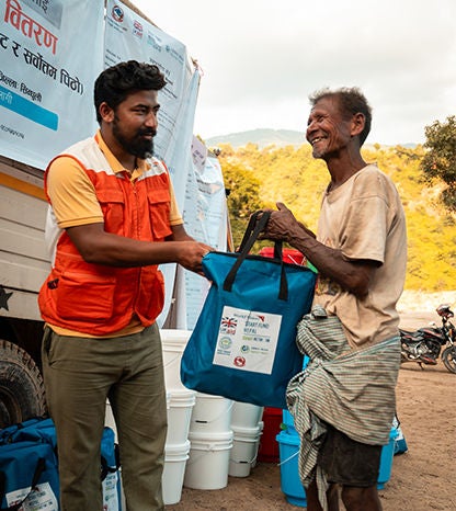 A World Vision staff distributes hygiene Kkits and dignity kits to flood and landslide affected families and children.
