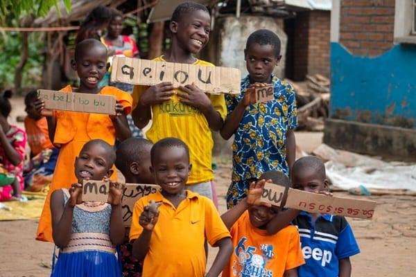 Children participating in a learning activity using handwritten word cards in their community.