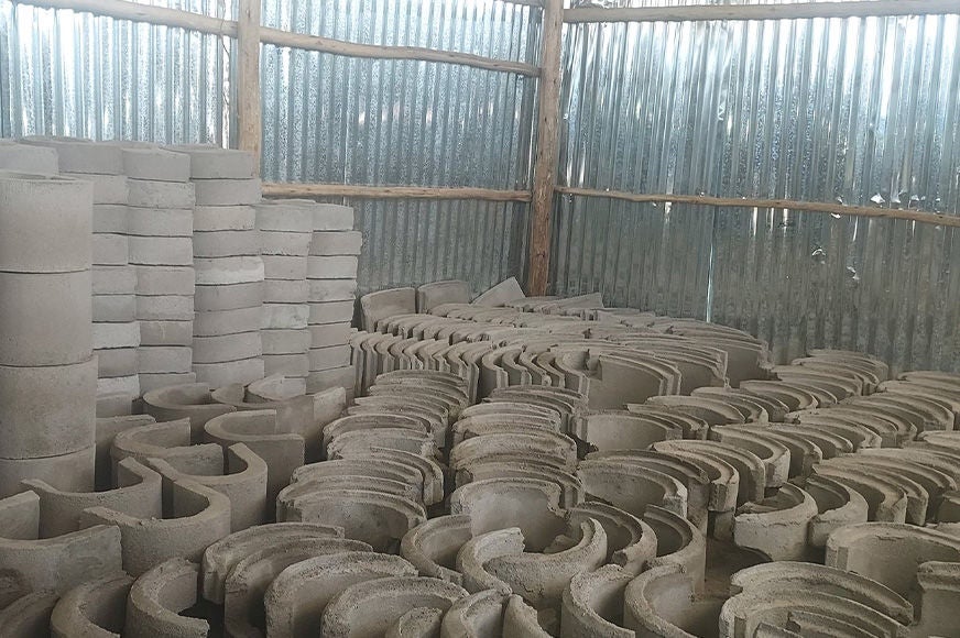 Moulded components of energy-efficient cookstoves are stored indoors.