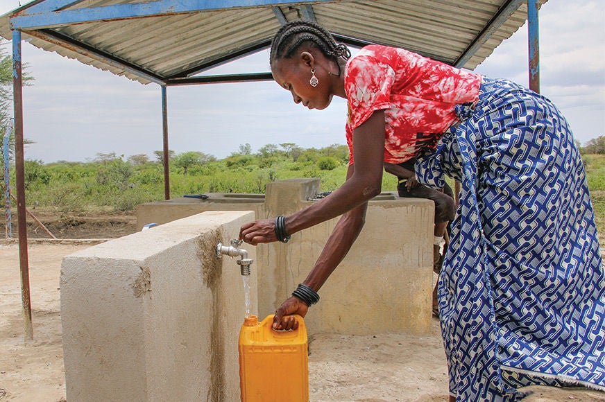 A woman collects water from a clean water station built by World Vision in partnership with her community. (Angola, 2024)