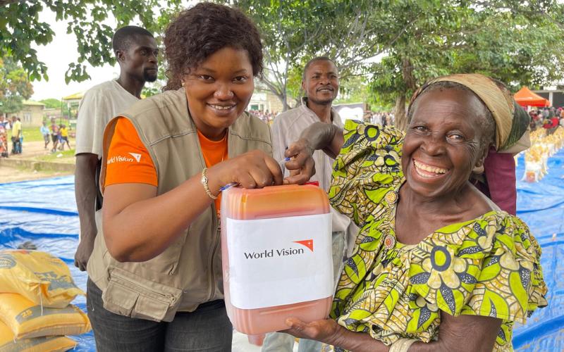 Two women in Kimbanseke, Democratic Republic of the Congo, hold a container of cooking oil being provided through food distributions.