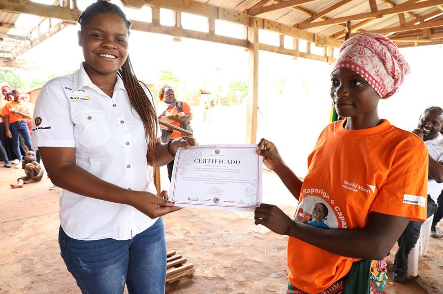 A young woman receives a graduation certificate.