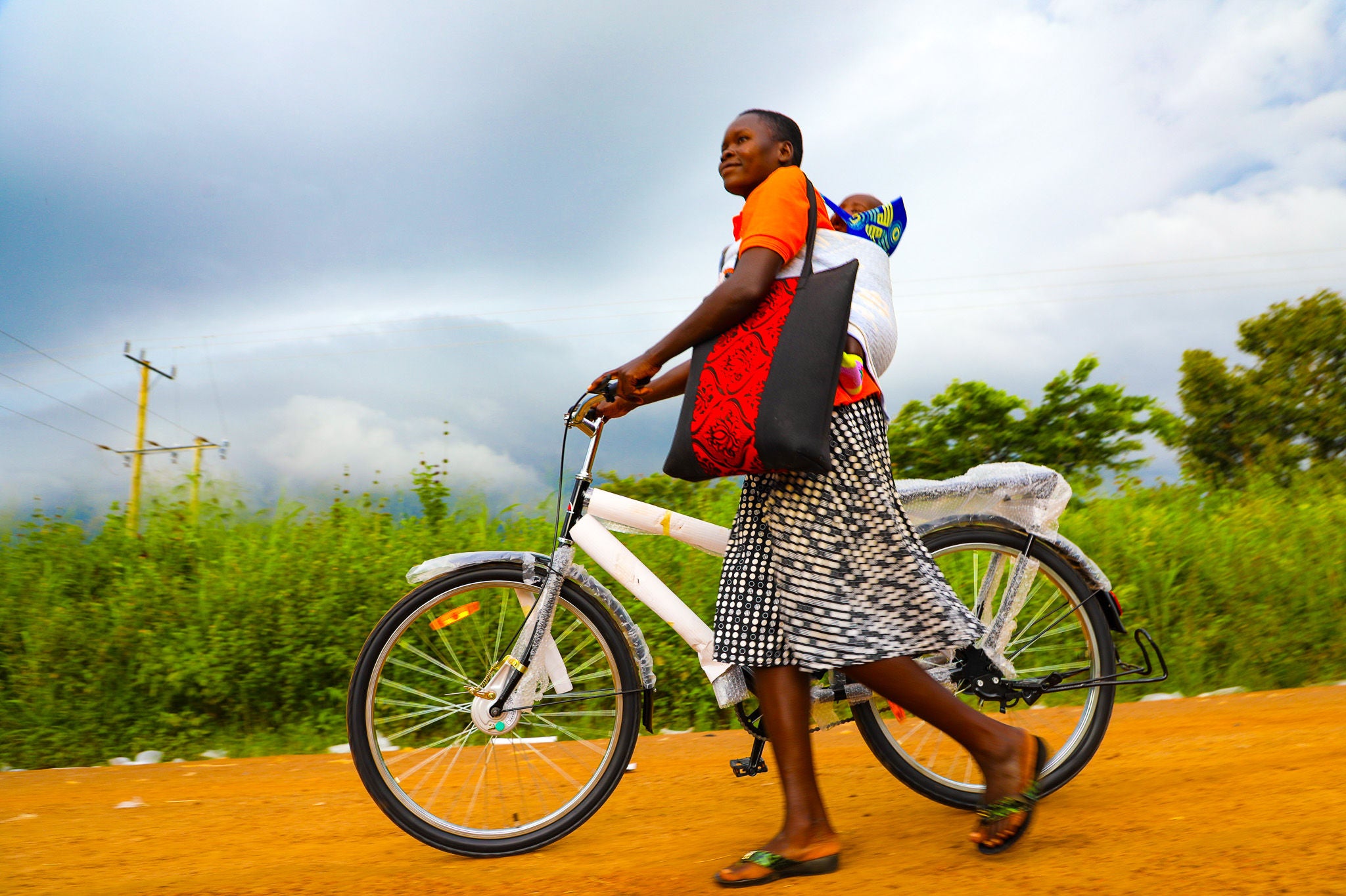 30- year-old Apio tries out her bicycle after receiving it. With the bicycle, Apio reach more children and families with timely health care services.