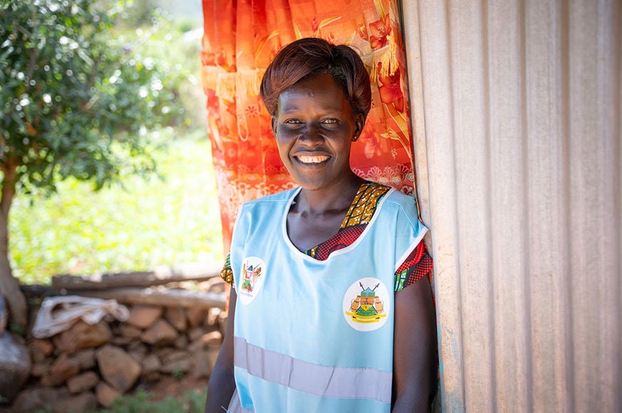 A woman in blue smiles.