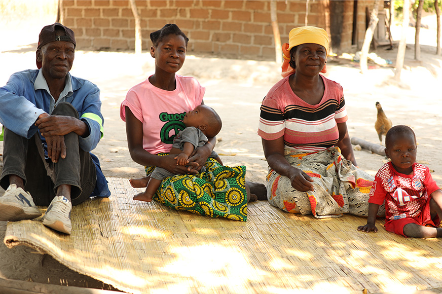 Guilhermina (centre) with her son, supportive parents Gabriel and Adelaide, and one of her six siblings.  A young woman holding a small child, sits on the floor beside her parents and younger brother. 