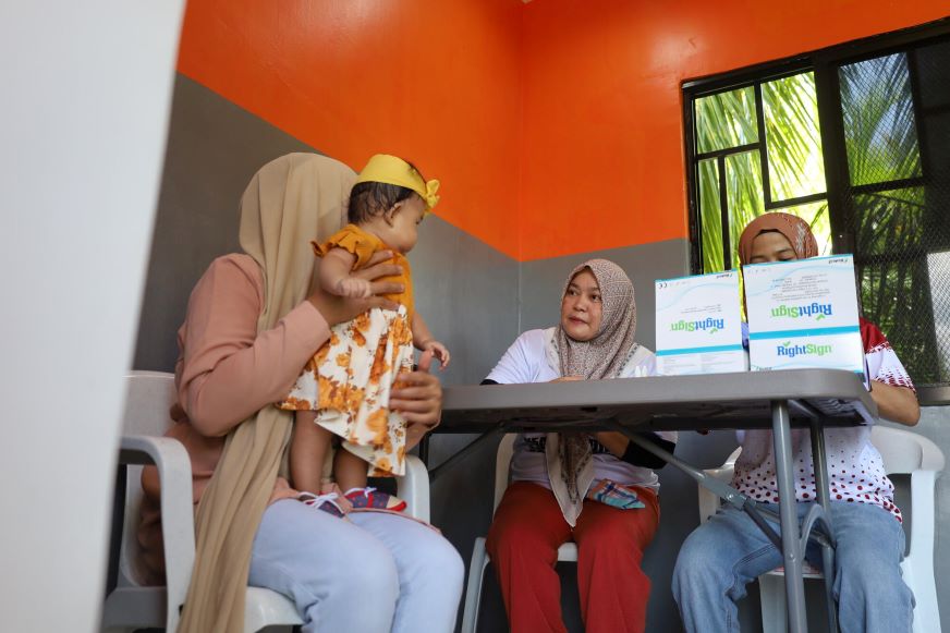 Bai Tayan is talking through the screening process at the breastmilk bank. 
