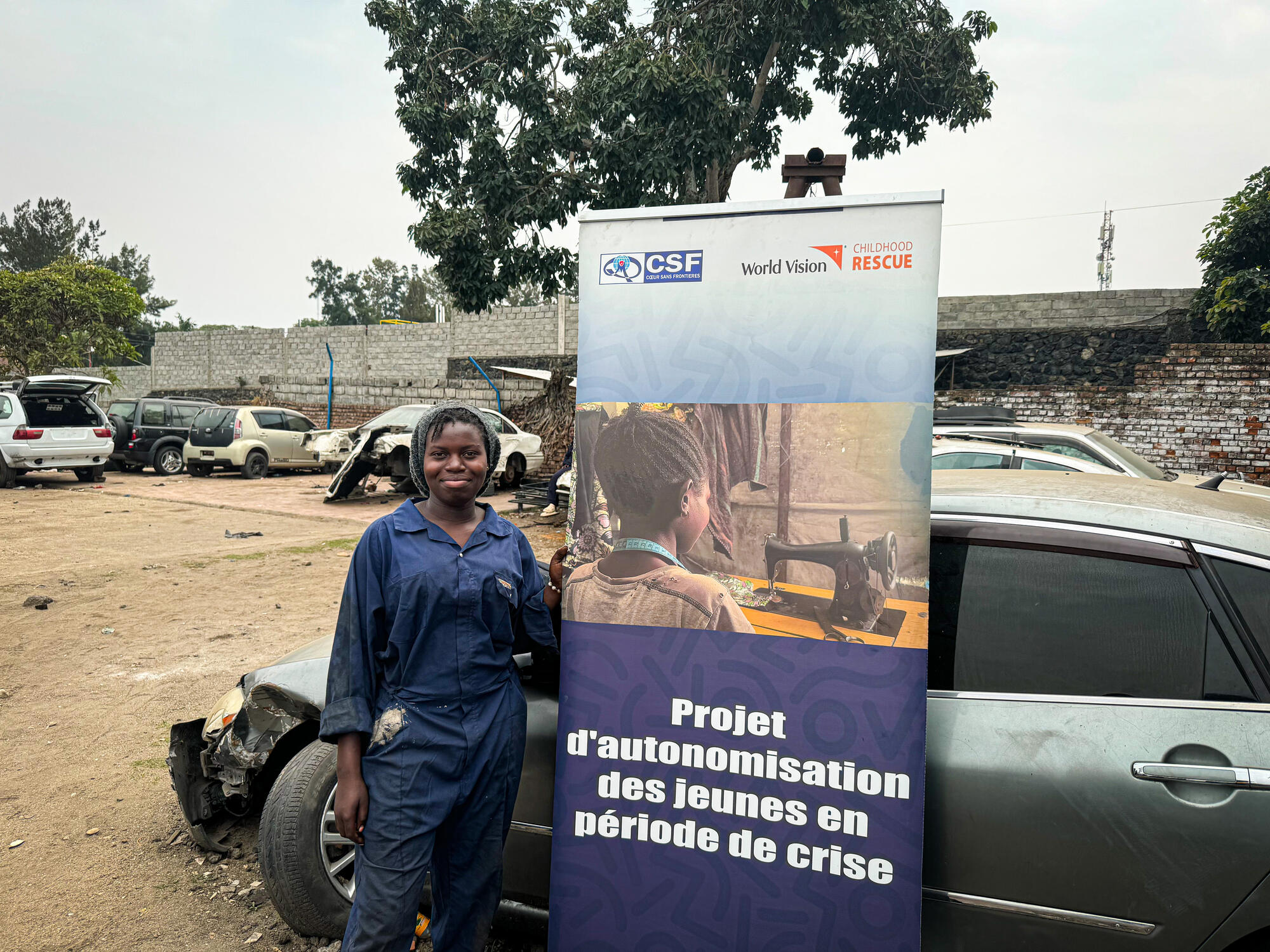 Immaculée smiles at the auto mechanic garage where her training is taking place.